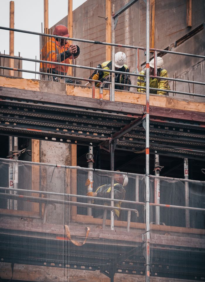 Home Construction workers engage in building tasks on a scaffold in Hamburg.
