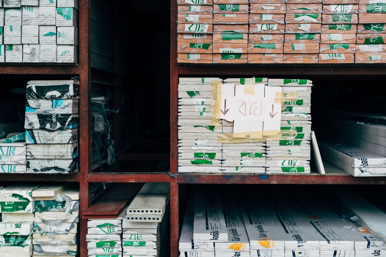 Home Image of a warehouse showcasing organized stacks of building materials on shelves.